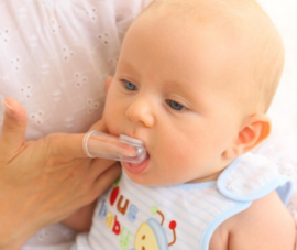 Cleaning the oral cavity of the baby with a special pad